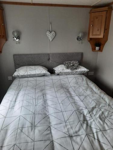 a bedroom with a large bed with a heart on the wall at Millfields 4 berth caravan DG & CH family's only and lead person must be over 30 in Ingoldmells