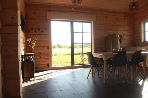 a dining room with a table and chairs and a window at Dundaga Axe & Archery guesthouse in Dundaga