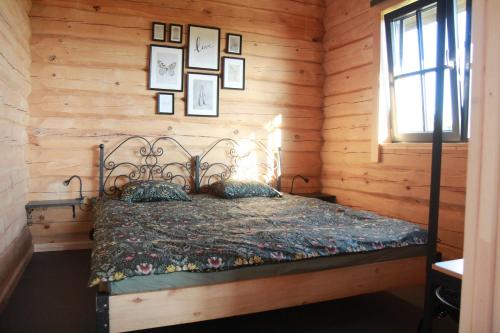 um quarto com uma cama num chalé de madeira em Dundaga Axe & Archery guesthouse em Dundaga