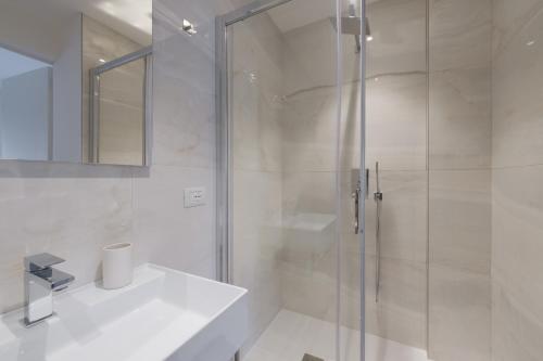 a white bathroom with a shower and a sink at Supernova in Savona