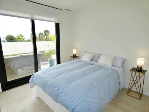um quarto branco com uma cama grande e uma janela grande em London Beach Benidorm em Finestrat