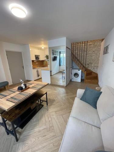 un salon avec une table et un canapé blanc dans l'établissement Agréable maison de ville, à Saujon