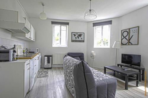 une cuisine et un salon avec un canapé et une table dans l'établissement CosyRouen Gare, à Rouen