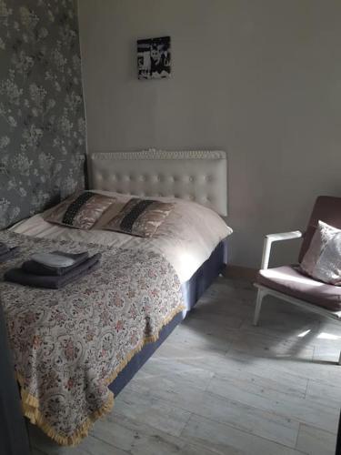 een slaapkamer met een bed met een stoel en een bed sidx sidx sidx bij Lovely_apartment in Tbilisi City