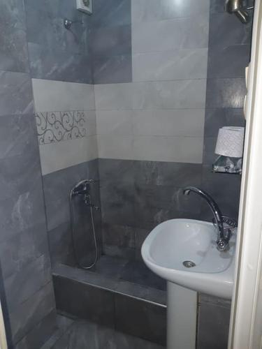 een badkamer met een wastafel en een douche bij Lovely_apartment in Tbilisi City