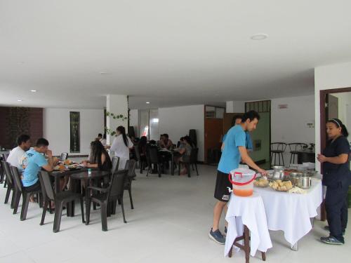a group of people standing around a table with food on it at Hotel Habitat in Ibagué