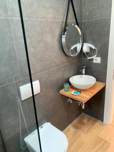 a bathroom with a sink and a mirror and a toilet at Villa Saral Mar in Sarandë