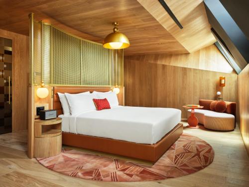 a bedroom with a large bed and a chair at W Budapest in Budapest