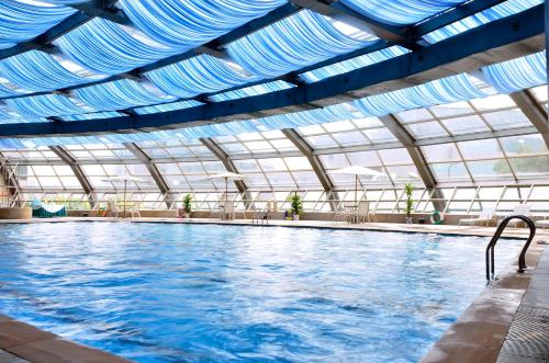 een groot zwembad met een blauw plafond bij Narada Grand Hotel Zhejiang in Hangzhou