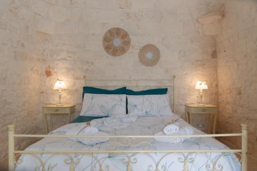 um quarto com uma cama branca com duas mesas de cabeceira em Trulli Vulés em Ostuni
