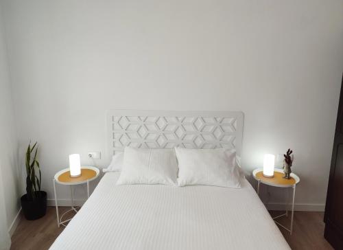 1 dormitorio con 1 cama blanca y 2 mesitas de noche en Voga Voga, en Corcubión