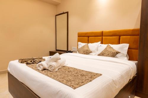 a bedroom with a large white bed with a mirror at LK GRAND HOME in Tirupati