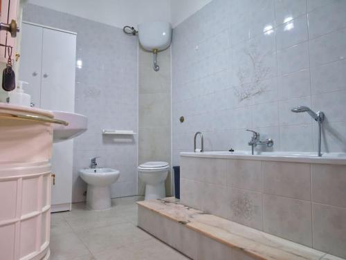 a bathroom with a sink and a tub and a toilet at Casa vacanze BellaVista in Iglesias