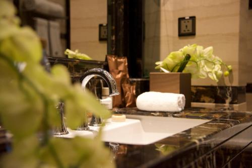 a bathroom counter with a sink and a mirror at Narcissus Riyadh Hotel & Spa in Riyadh