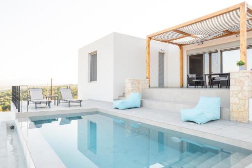 a villa with a swimming pool and a house at Sunset Luxury Villa in Akritokhórion