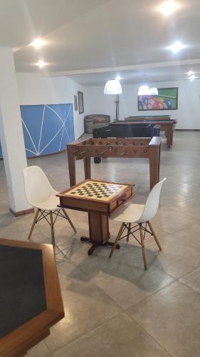 a living room with a table and two chairs and a pool table at Apartamento em Praia Grande - Le Bon Vivant - Arraial do Cabo in Arraial do Cabo