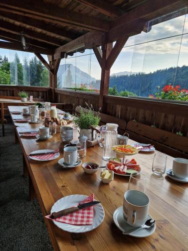 a long wooden table with plates of food on it at Zauneralm in Aich