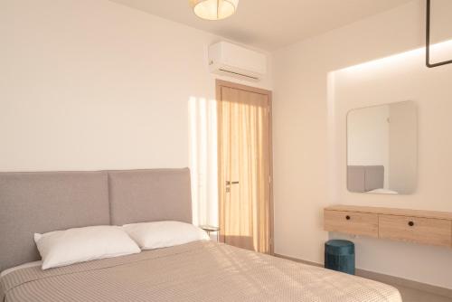 a bedroom with a bed and a mirror at Sunset Luxury Villa in Akritokhórion