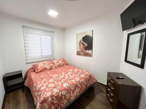 um quarto com uma cama e uma fotografia na parede em Hospedaje Nuevo Amanecer em Antofagasta