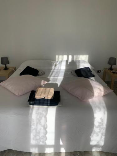 un letto bianco con due cuscini e asciugamani di Casa Luce a Brindisi Montagna