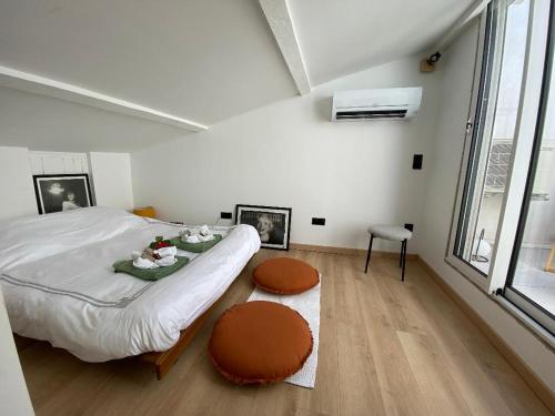 une chambre blanche avec un lit et une grande fenêtre dans l'établissement Sunsète appartement T3 duplex centre ville avec terrasse et balcon, à Sète