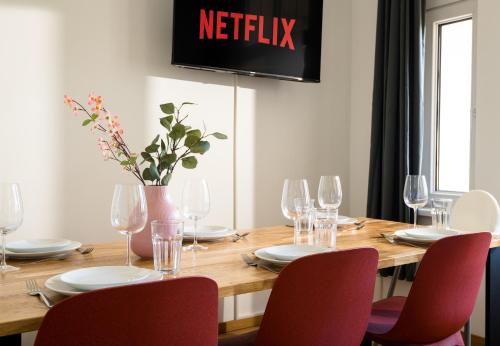 a dining room table with red chairs and a television at Sehr zentrale Unterkunft nähe des Bahnhofs in Leipzig für bis zu 10 Personen in Leipzig