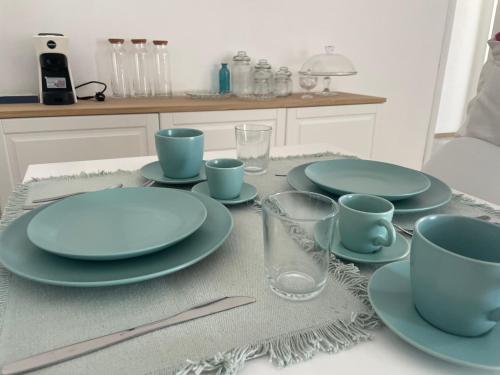a table with blue plates and cups on it at A Casa dei Miei in Otranto