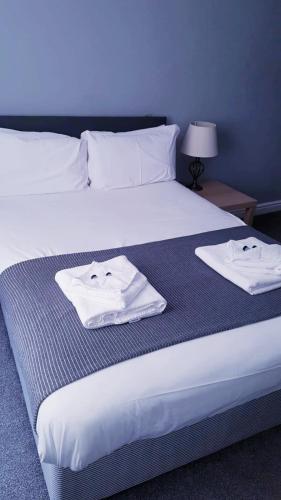 a bedroom with a bed with two towels on it at The Grey Horse in Darlington