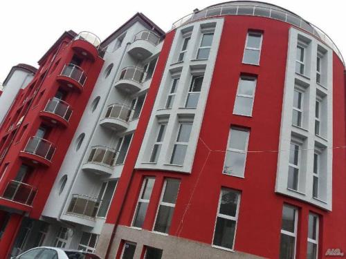 un edificio rosso accanto a due edifici alti di Luxury Apart a Stara Zagora