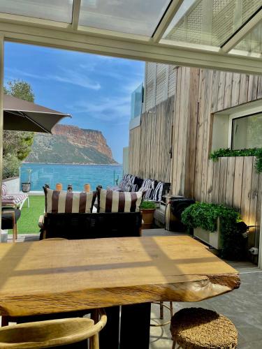 a patio with a wooden table and a view of the ocean at Hotel de La Plage - Mahogany in Cassis