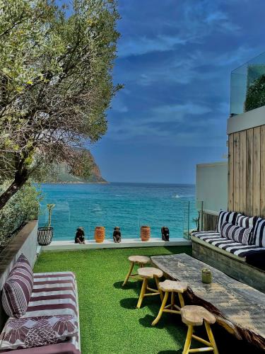 a patio with a table and chairs and the ocean at Hotel de La Plage - Mahogany in Cassis