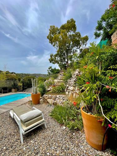 a chair sitting on the gravel next to a pool at Hotel de La Plage - Mahogany in Cassis