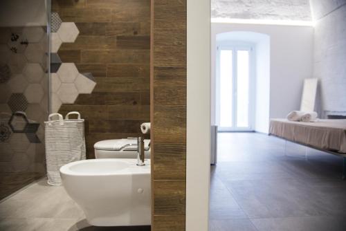 a bathroom with a toilet and a sink and a bed at Il Cocchiere in Palagianello