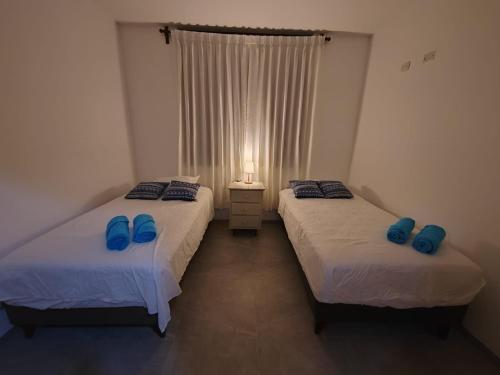 two beds in a room with blue pillows on them at Albamar - Casa Antonio - Beach house in El Ñuro