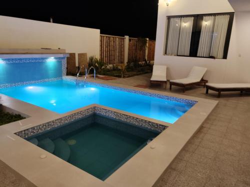 a swimming pool in the middle of a backyard at night at Albamar - Casa Antonio - Beach house in El Ñuro
