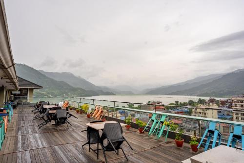 a balcony with chairs and tables and a view of a river at Hotel Sarowar Pokhara-Luxury Hospitality in the Heart of Pokhara in Pokhara