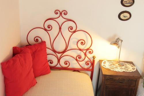 a red bed with two red pillows next to a table at Agriturismo Ponterosa in Morrovalle
