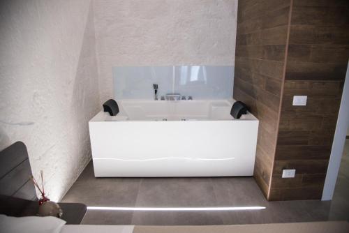a bathroom with a white bath tub in a room at Il Cocchiere in Palagianello