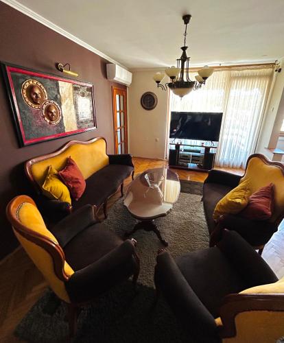 een woonkamer met 2 banken en een tafel bij Baroque-style apartment in Štip