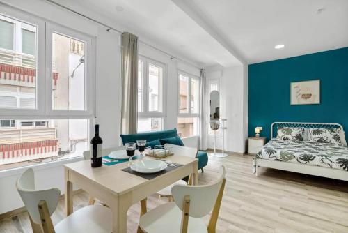 a living room with a table and chairs and a couch at Umihouse apartamentos centro Alicante in Alicante