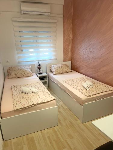 a bedroom with two beds and a window at Apartments Glitter in Mostar