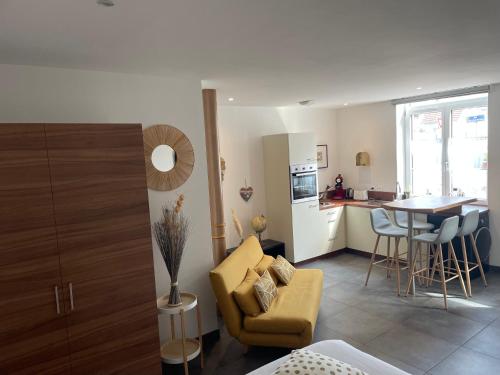 ガイスポルスハイムにあるGîte de la bonne étoileのリビングルーム(黄色のソファ付)、キッチンが備わります。