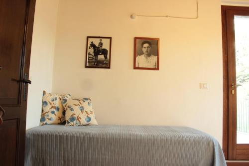 a bedroom with a bed and two pictures on the wall at Agriturismo Ponterosa in Morrovalle