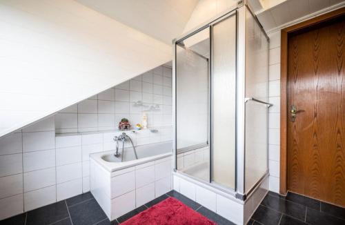 uma casa de banho com uma banheira e um chuveiro com um tapete vermelho em Luxe woning 14 pers 6 slaapkamer 
