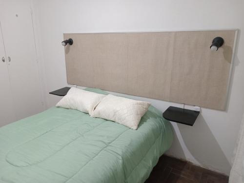 a bed with a headboard and two pillows on it at Dpto Saavedra in Tres Arroyos