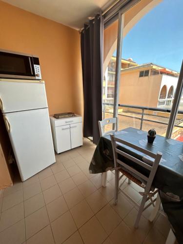Il comprend une cuisine équipée d'une table et d'un réfrigérateur. dans l'établissement Studio Vue Mer situé à côté de la plage Quartier des Quilles, à Sète