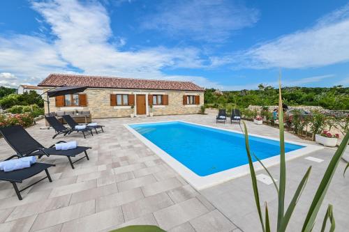 a villa with a swimming pool and patio furniture at Villa Nika in Novalja