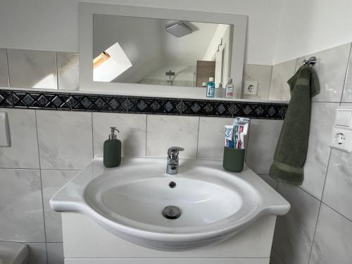 a white sink in a bathroom with a mirror at Ferienwohnung Zentral in Lörrach - KONUS Gästekarte inklusive in Lörrach
