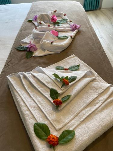 a table with two towels with flowers on it at Güneş Boutique Hotel - Oludeniz in Oludeniz