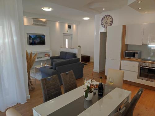 a kitchen and living room with a table and a couch at Apartman Vlatka 